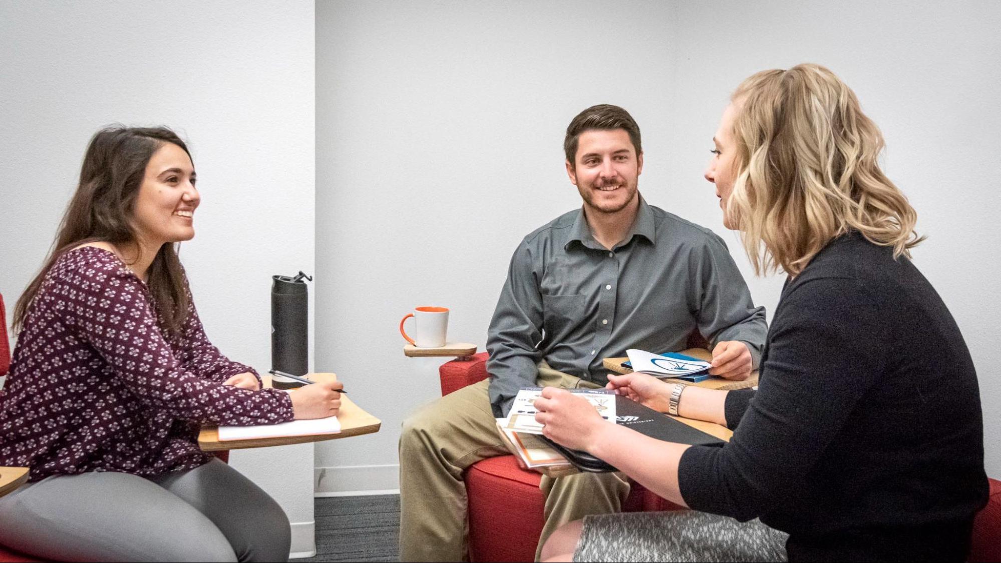 Businesswoman discussing marketing plans with two clients.